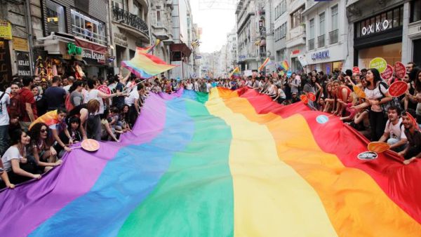 People hold a giant rainbow flag during a gay parade on June 30, 2013 in Istanbul. [AFP/Gurcan Ozturk]
