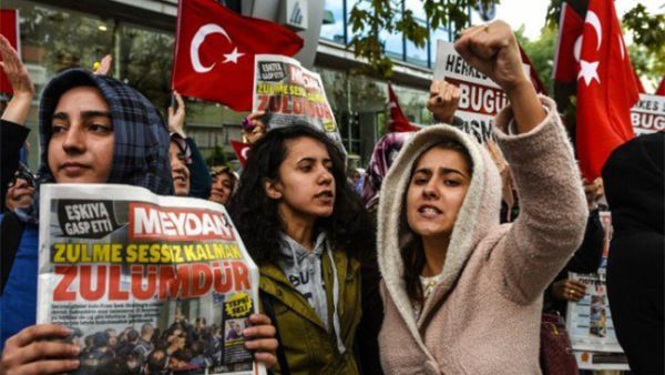 Turkish protesters shout slogans outside the headquarters of Bugun newspaper and Kanalturk television station in Istanbul. (AFP)