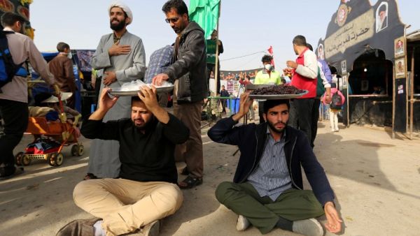 Volunteers offer food to fellow pilgrims as thousands of Iranian Shiite Muslims prepare to cross the Mehran border point between Iran and Iraq, heading toward the central Iraqi shrine city of Karbala, on October 28, 2018. (ATTA KENARE / AFP)