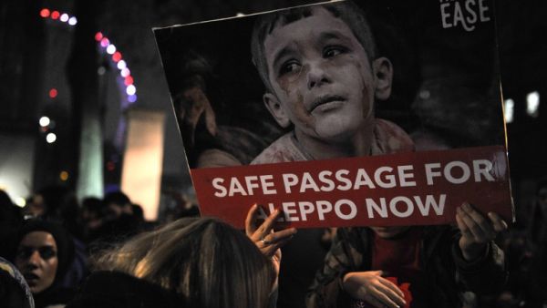 Protesters hold placards during a demonstration in solidarity with the inhabitants of the embattled Syrian city of Aleppo, outside the entrance to Downing Street, in central London on December 13, 2016. (AFP/Daniel Sorabji)