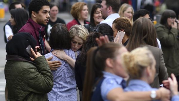 Retail staff hug each other after being evacuated from the Arndale Centre shopping mall in Manchester, northwest England on May 23, 2017 following a security alert the day after a deadly terror attack at the Manchester Arena. (AFP/Ben Stansall)
