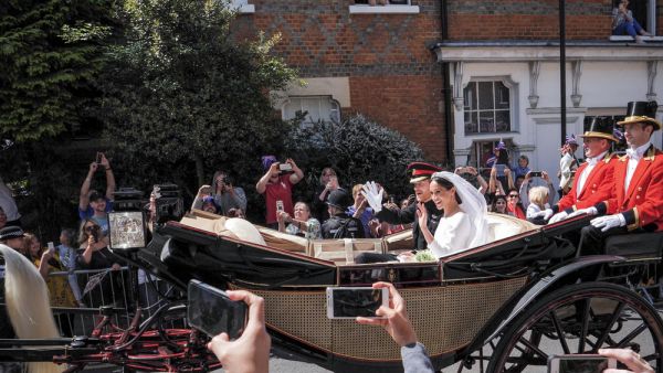 Prince Harry, Duke of Sussex and Meghan Markle, Duchess of Sussex leave Windsor Castle in Ascot Landau carriage during a procession after getting married at St Georges. (Shutterstock)
