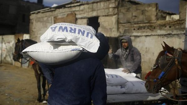 Palestinian loads a horse-pulled cart with food donations outside the United Nations food distribution center in Gaza City on January 15, 2018 (AFP PHOTO / Mohammad Abed)