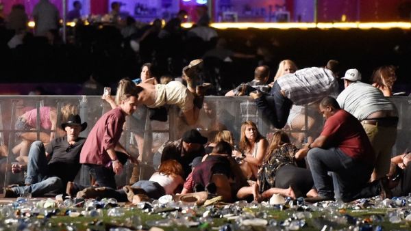 People scramble for shelter at the Route 91 Harvest country music festival after apparent gun fire was heard on October 1, 2017 in Las Vegas, Nevada (David Becker/Getty Images North America/AFP)
