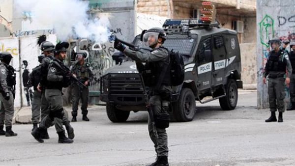 An Israeli soldier fires tear gas towards Palestinian protesters during clashes in the occupied West Bank city of Bethlehem on March 22, 2017. (AFP)