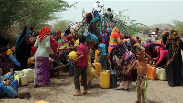 Yemenis gather next to a water tank to collect water in an impoverished coastal village on the outskirts of the Yemeni port city of Hudaydah, on May 12, 2018. (AFP Photo)
