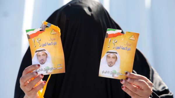كويتية تحمل ملصقات دعائية لمرشح بعد خروجها من مركز اقتراع/أ.ف.ب