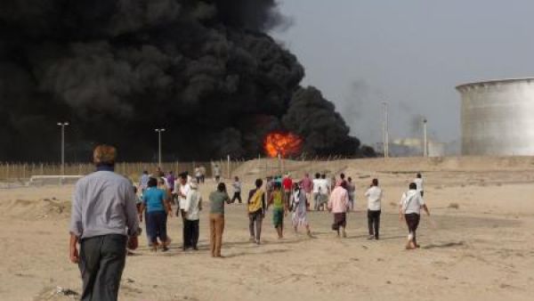 أشخاص يتجمعون في موقع اشتعال نيران بسبب قذائف أطلقها مقاتلون حوثيون على صهاريج تخزين النفط في عدن
