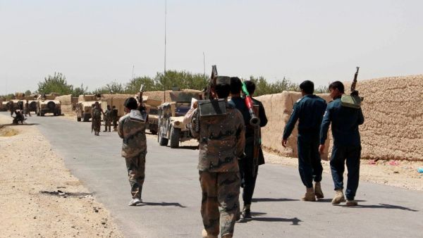 Afghan security personnel walk as they prepare for combat during an ongoing battle with Taliban militants in the Nad Ali district of Helmand on August 10, 2016. (AFP/Noor Mohammad)
