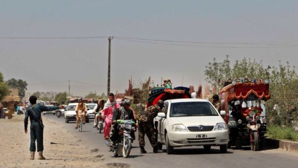 Afghan policemen search commuters at a checkpoint in Helmand province on August 9, 2016. (AFP/Noor Mohammed)