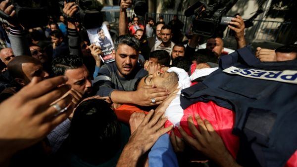 Mourners and journalists carry the body of Palestinian journalist Yasser Murtaja, during his funeral in Gaza. The Israeli army admitted he was shot dead despite posing no threat. (AFP/File Photo)	