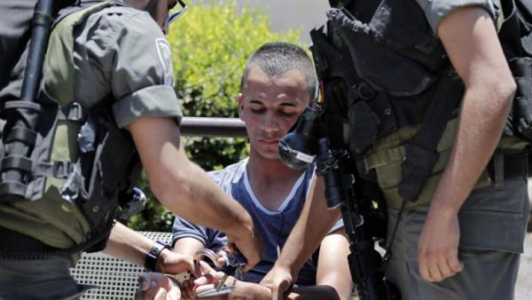 A Palestinian minor is arrested for stone throwing following clashes in Jerusalem's Old City, July 24, 2014. (AFP/File)