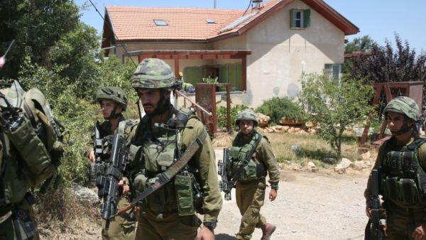 Jewish settlers with Israeli troops converged on a Palestinian town that was scene of fierce confrontations last month. (AFP/File Photo)