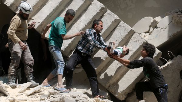Rescue workers and volunteers save a baby from a collapsed building after airstrikes hit rebel-held areas of Aleppo in late April, 2016.  (AFP/Ameer Alhalbi)