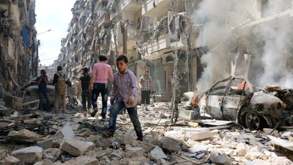 People walk amid the rubble of destroyed buildings following a reported air strike on the rebel-held neighborhood of al-Kalasa in the northern Syrian city of Aleppo, on April 28, 2016. (AFP/Ameer al-Halbi)