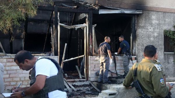 Security forces inspect the West Bank house destroyed in an arson attack on July 31, 2015. (AFP/Jaafar Ashtiyeh)