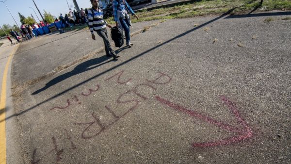"Austria 2 min" is written on the ground near a temporary bus station as migrants arrive at the Hungarian-Austrian border on Sept. 12, 2015, near Nickelsdorf, eastern Austria. (AFP/Joe Klamar)