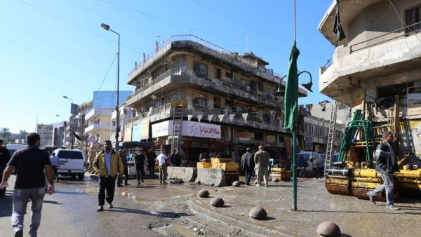 Iraqis clean the scene of a bomb explosion that targeted a group of workers at Tayaran square in Baghdad early on March 29, 2016. (AFP/Sabah Arar)