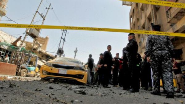 Iraqis gather at the site of a car bombing near Baghdad's Al-Shuhada Bridge on May 30, 2017. (AFP)