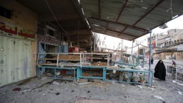 سيدة تمر بموقع هجوم بسيارة ملغومة في بغداد
