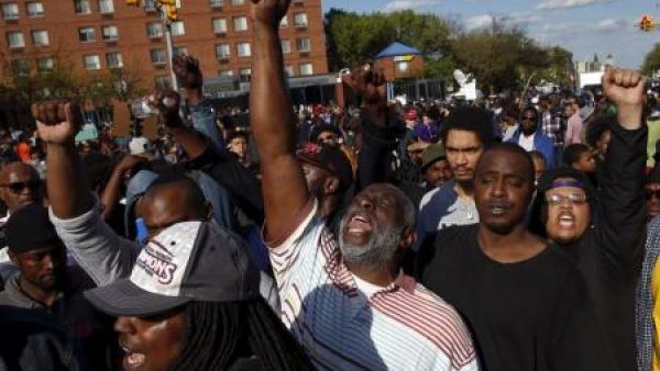 متظاهرون يقفون أمام خط شرطة في بالتيمور بعد يوم من اعمال النهب واشعال الحرائق احتجاجا على وفاة فريدي جراي يوم الثلاثاء
