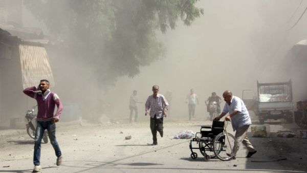 Syrian men react following a reported barrel bomb attack by Syrian government forces. (AFP/Karam al-Masri)