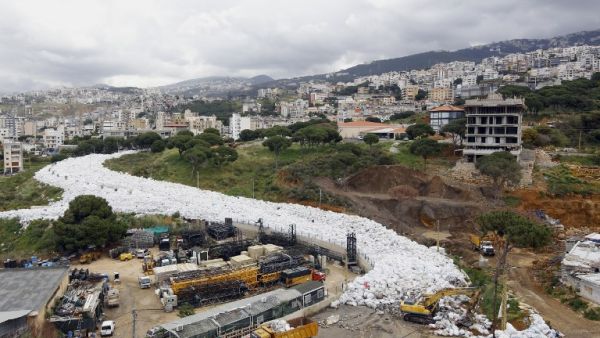 Trucks are seen next to piles of garbage in Jdeideh, a Beirut suburb, ahead of moving it to the country's largest landfill of Naameh, just south of the Lebanese capital, on March 20, 2016. (AFP/Anwar Amro)