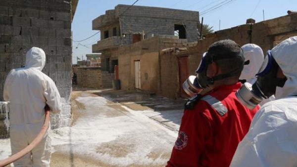 Members of the civil defence spray and clean areas in the town of Taza, around 220 kilometres north of the capital Baghdad, on Sunday. (AFP/File)