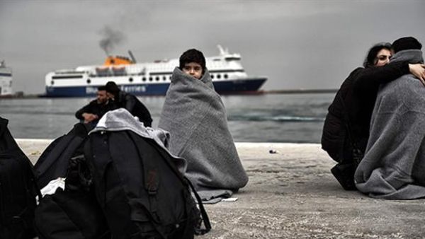Children wrapped in covers stand in a harbour as migrants and refugees arrive on the Greek island of Lesbos while crossing the Aegean Sea from Turkey on March 2, 2016, in Mytilene. (AFP/File)