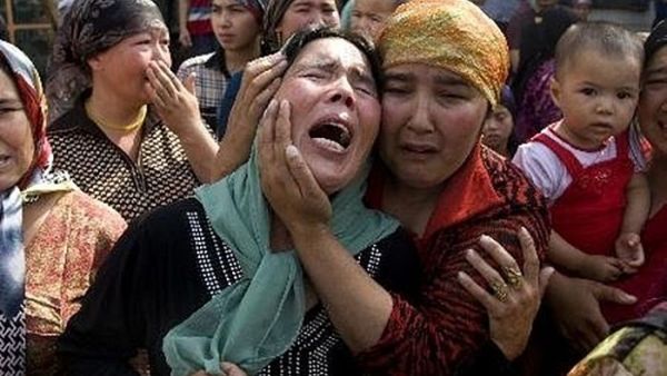 ارشيف/ نساء مسلمات ينتحبن اثر مقتل 15 شخصا في هجوم بالقنابل والسكاكين في منطقة شينجيانغ عام 2014
