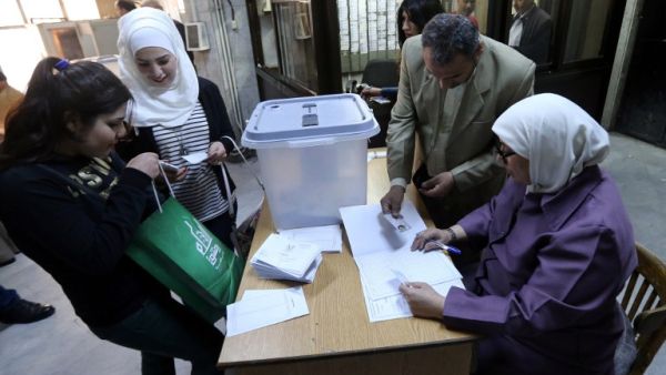 Syrians register to cast their votes at a polling station during parliamentary elections in Damascus on April 13, 2016. (AFP/Joseph Eid)