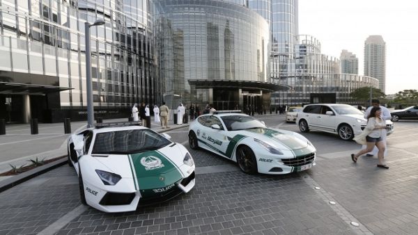 A picture taken on April 25, 2013 shows a Lamborghini (L) and Ferrari police vehicles at the foot of the Burj Khalifa tower in Dubai. (AFP/ Karim Sahib)