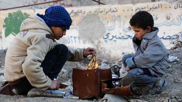 Syrian boys make a fire in Kafr Batna in the rebel-held Eastern Ghouta area, on the outskirts of the capital Damascus on Jan. 21, 2017 (AMER ALMOHIBANY/AFP)