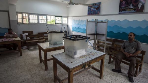 Egypt election officials sit at an empty polling station on the second day of voting, Oct. 19, 2015. (AFP/File)