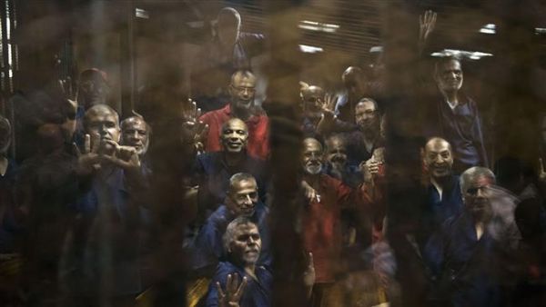 Egyptian Muslim Brotherhood defendants stand behind the bars during their trial. (AFP/File)