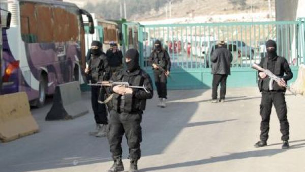 مقاتلون من جيش الفتح يخفرون منطقة خلال اجلاء بالحافلات مقاتلين ومدنيين من بلدتي الفوعة وكفريا الشيعيتين في ادلب 
