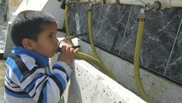 A boy takes a drink from emergency water supplies being distributed by the UN. (AFP/File)