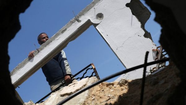 A Palestinian worker checks a house that was destroyed during the 50-day war between Israel and Hamas-led militants in the summer of 2014, east of Gaza City on March 23, 2016. (AFP/Mohammed Abed)