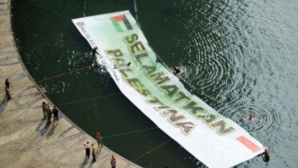 نشطاء اندونيسيون يرفعون يافطة عملاقة كتب عليها "انقذوا فلسطين"/أ.ف.ب