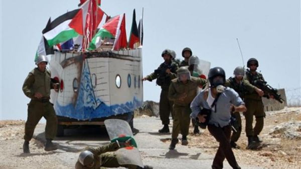 صحفي اجنبي يهرب من مطاردة جنود اسرائيليين خلال احتجاج في بلدة بعلين الفلسطينية، الجمعة،أ.ف.ب