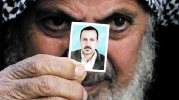 والد المبحوح يحمل صورة له