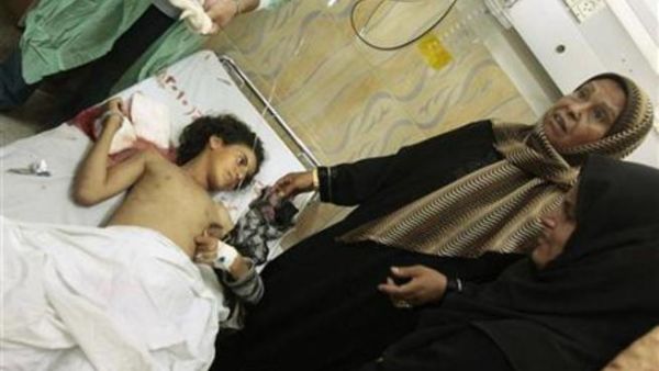 فلسطينية تقف بجوار فتاة مصابة في مستشفى بيت حانون شمال قطاع غزة بعد قصف اسرائيلي يوم الاربعاء