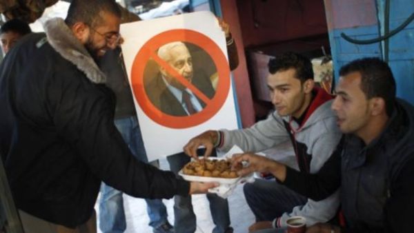 فلسطينيون يوزعون حلوى في شوارع غزة احتفالا بوفاة شارون/أ.ف.ب