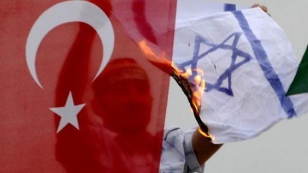 متظاهر يحرق علما اسرائيليا خلف علم تركي في 5 حزيران/يونيو في اسطنبول