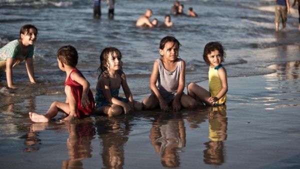 Children play in the water in Gaza City (AFP/File Photo)