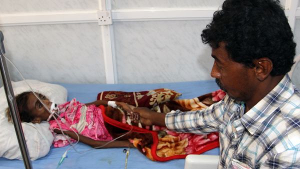 A Yemeni tends to his malnourished child as she receives treatment at a hospital in the Yemeni port city of Hodeidah. (AFP/File)