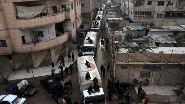 A Red Crescent convoy carrying humanitarian aid arrives in Kafr Batna, in the rebel-held Eastern Ghouta area, outside Damascus on Feb. 23, 2016 during an operation to deliver aid to thousands of besieged Syrians. (AFP/Amer al-Mohibany)