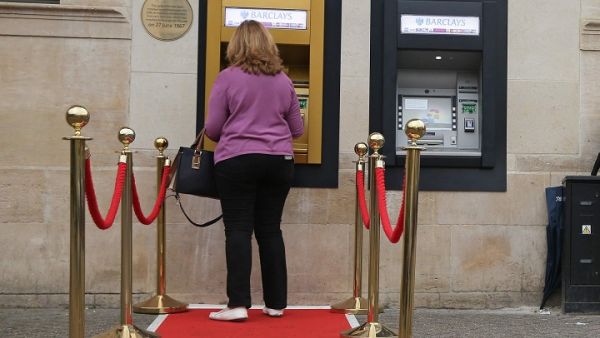 A woman uses a golden ATM on the 50th anniversary of the world's first cash machine. (Daniel Leal-Olivas/ AFP)
