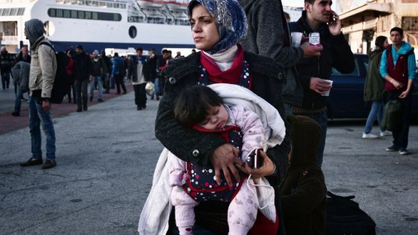 A woman holds her baby as migrants wait at the port of Piraeus on February 23, 2016 upon their arrival from the islands of Lesbos and Chios. (AFP/Louisa Gouliamaki)