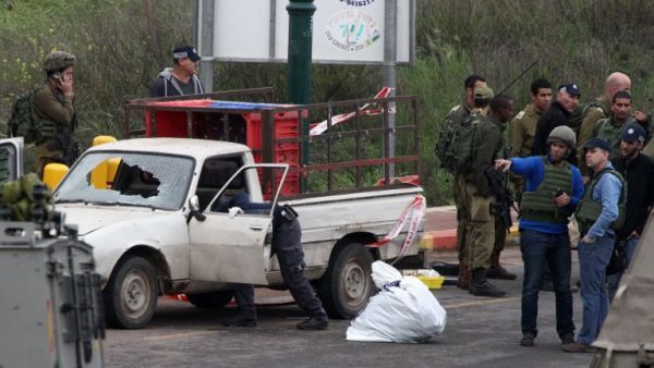 Israeli security forces stand guard at the scene where three Palestinians carried out two attacks -- a shooting and a car ramming -- on Israelis at the entrance of the Israeli settlement of Kiryat Arba near Hebron on March 14, 2016. (AFP/Hazem Bader)